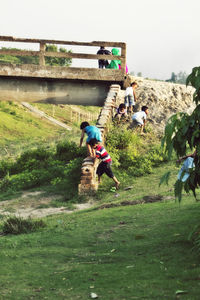 Full length of young woman jumping on grass