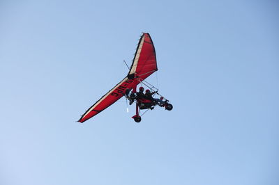 Low angle view of hang glider against clear blue sky