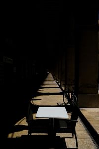 Empty bench in row against building