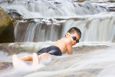 Portrait of boy enjoying in waterfall