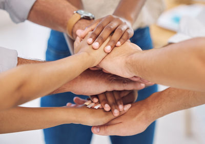 Cropped image of people stacking hands
