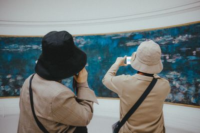 Rear view of friends standing at shore during winter