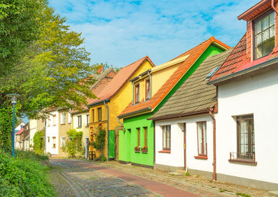 Houses by street amidst buildings in town