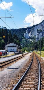 Railroad tracks by train against sky