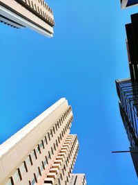 Low angle view of buildings against clear blue sky