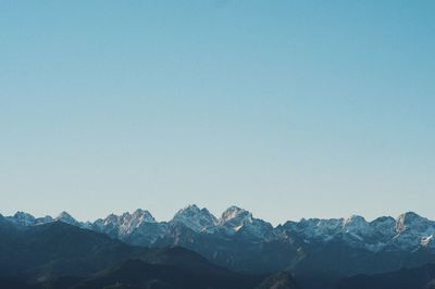 Scenic view of snowcapped mountains against clear blue sky