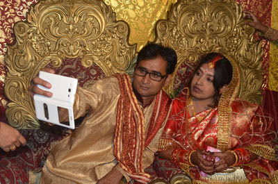 Indian groom taking selfie with wife