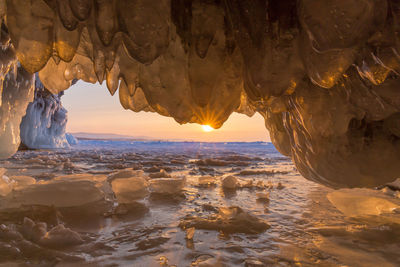 Scenic view of frozen sea against sky during sunset