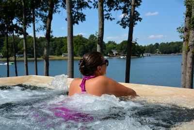 Rear view of woman by lake in swimming pool