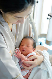 Mother carrying daughter at home