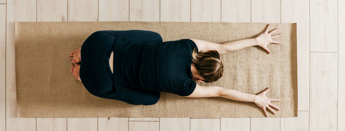 Rear view of woman sitting on hardwood floor