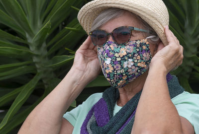 Midsection of woman wearing hat holding purple outdoors