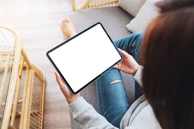 Midsection of woman using digital tablet