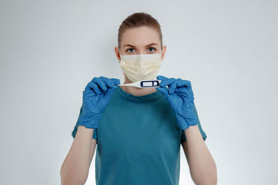 Portrait of young woman standing against white background