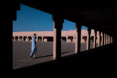 Rear view of woman standing against clear sky