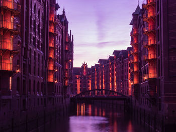 Reflection of buildings in city at sunset