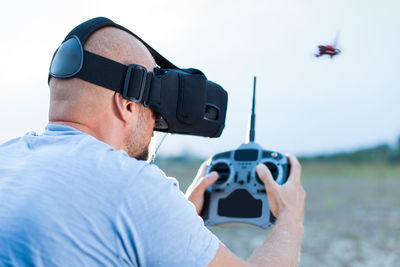 Man using virtual reality simulator while flying drone