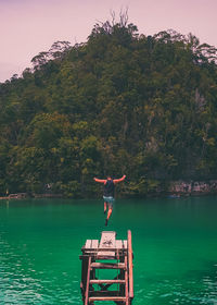 Man standing by lake against trees