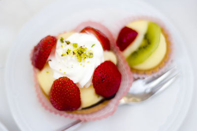 Directly above shot of strawberry cake in plate against white background