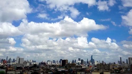 View of cityscape against cloudy sky