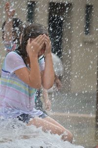 Girl sitting by fountain