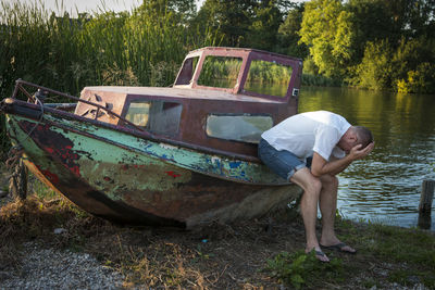 Side view of man in boat against trees