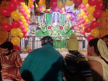 Rear view of people standing at balloons