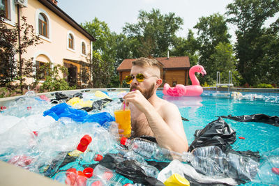 Midsection of shirtless man in swimming pool