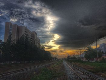 Railroad tracks against cloudy sky