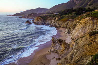 Scenic view of sea and mountains against sky