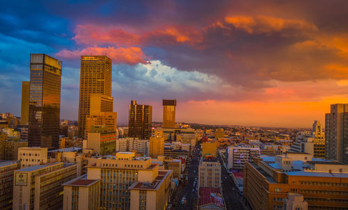 Modern buildings against sky during sunset