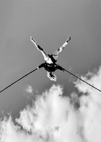Low angle view of person on rope against sky