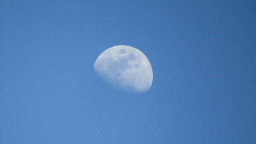 Low angle view of moon against blue sky