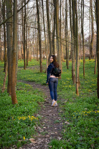 Full length rear view of woman walking in forest