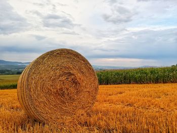 Hay bales on field against sky