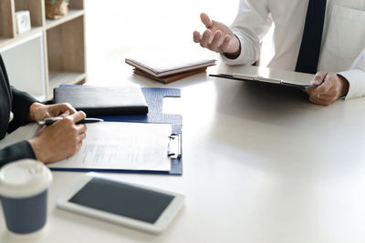 Man using mobile phone and book on table