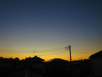 Silhouette buildings against clear sky at sunset