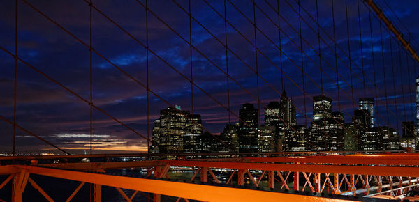 View of suspension bridge in city against sky