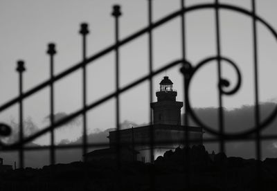 Lighthouse seen through metal gate