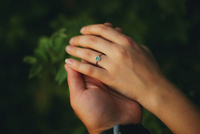 Love, couple, relationship and holidays concept - close up of man giving diamond ring to woman. 