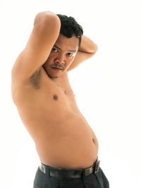 Portrait of shirtless man standing against white background