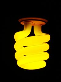 Close-up of illuminated light bulb against black background