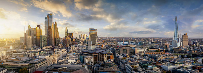 Modern buildings in city against cloudy sky