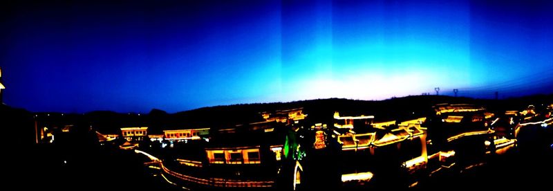 High angle view of illuminated buildings against sky at night