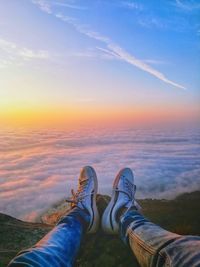 Low section of person against sky during sunset