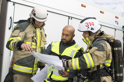 Security guard and firefighters discussing plan