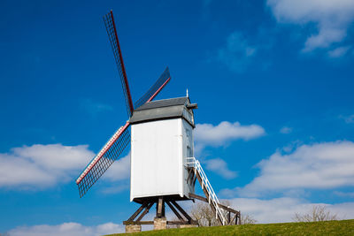Windmill under a beautiful blue winter sky just before spring at the historical bruges town