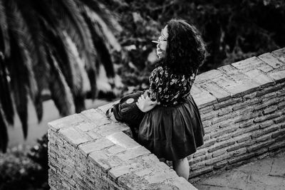 Rear view of woman sitting outdoors