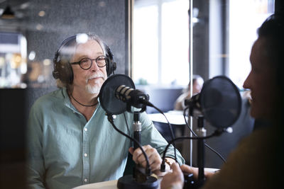 Male radio presenter talking with his guest on radio show or podcast