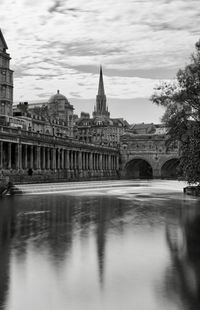 Bridge over river against buildings in city